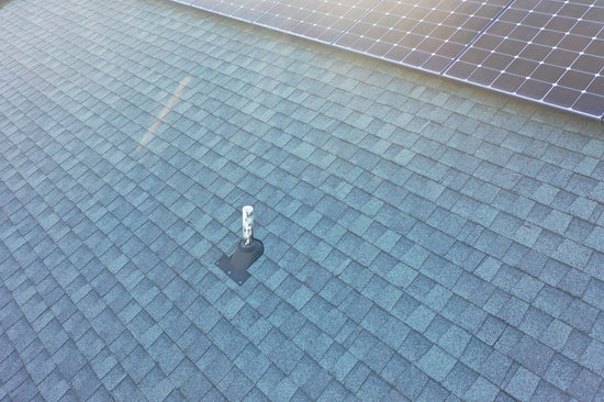 Aerial view of solar panels installed around a flashed roof vent pipe.